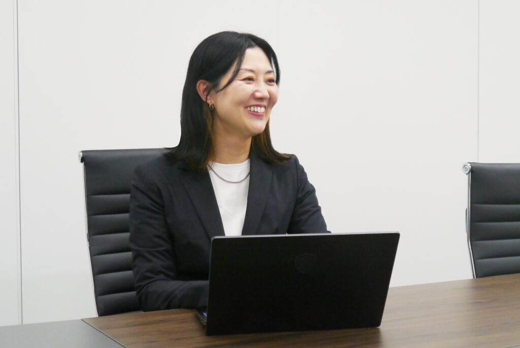 PCを目の前に笑顔でお仕事をする大嶌さん